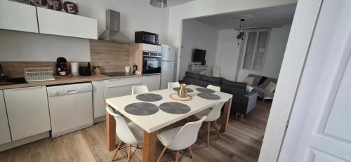 a kitchen and dining room with a table and chairs at La demeure du 159 in Cognac