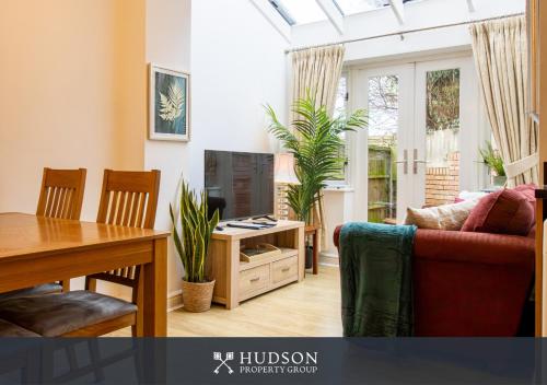 a living room with a couch and a tv and a table at Shrewsbury Apartment in Prime Location in Shrewsbury