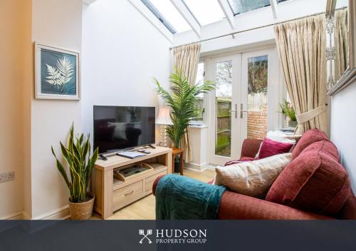 a living room with a couch and a television at Shrewsbury Apartment in Prime Location in Shrewsbury
