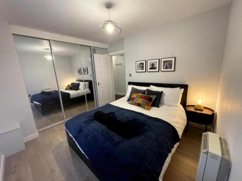 a bedroom with a large bed and a mirror at Central Industrial Chic 2-Bedroom Flat in Crewe
