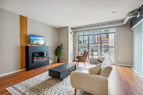 a living room with a couch and a tv at CozySuites 2BR Mill District with gym # 01 in Minneapolis