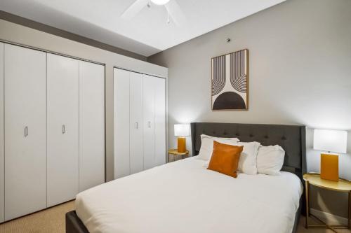 a bedroom with a white bed and white cabinets at CozySuites 2BR Mill District with gym # 01 in Minneapolis