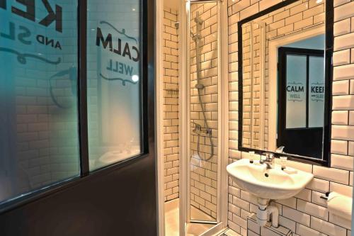 uma casa de banho com um lavatório e um espelho em Arty Paris Porte de Versailles by River em Paris