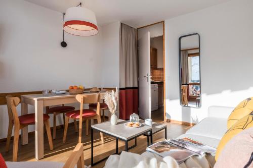 a small living room with a table and chairs at Résidence Pierre & Vacances Les Temples du Soleil in Val Thorens