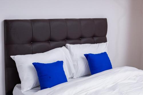 a bed with two blue pillows on top of it at Salama Blue Lodge in Lusaka