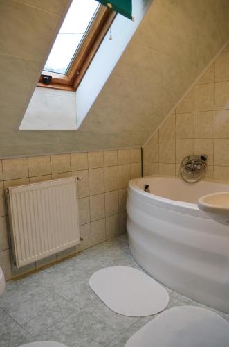 a bathroom with a white tub and a skylight at Dom na Mosornym Groniu in Zawoja