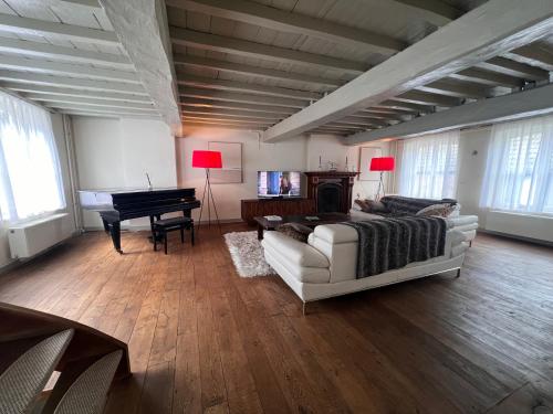a living room with a white couch and a piano at One Magnific 3 floors Authentic Dutch House with Terrace and One 2 bedrooms Deluxe modern apartment in Maastricht