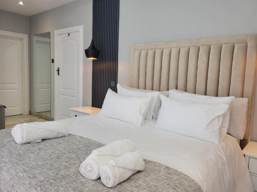 a bedroom with a large white bed with towels on it at Muyeni BnB in Harare