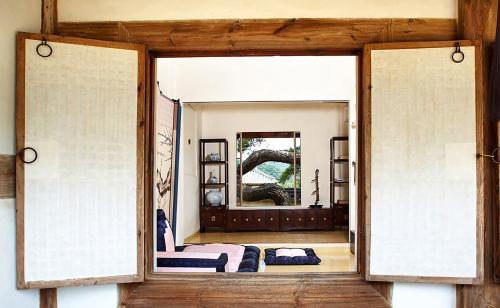 ein Zimmer mit einer Tür, die zum Wohnzimmer hin offen ist in der Unterkunft Bukchondaek in Andong