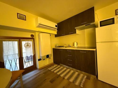 a kitchen with black cabinets and a white refrigerator at Casa nella Corte in Bellano