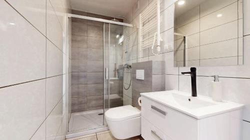 a bathroom with a shower and a toilet and a sink at Apartament Fibra Bounty in Rybnik