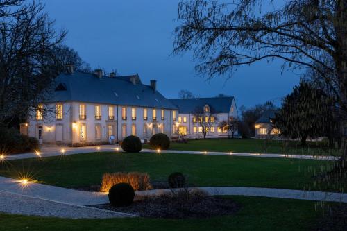 a large house with lights on a lawn at night at Château Saint Gilles - Bayeux in Guéron