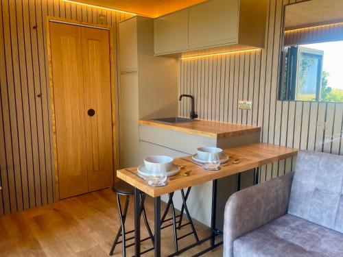 a kitchen with a counter and a table and a chair at Barefoot Beach Hut in Skegness