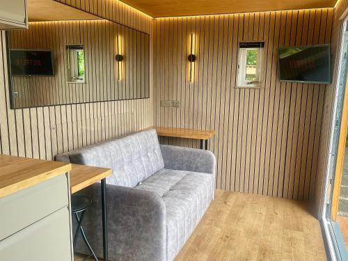 a living room with a couch and a table at Barefoot Beach Hut in Skegness