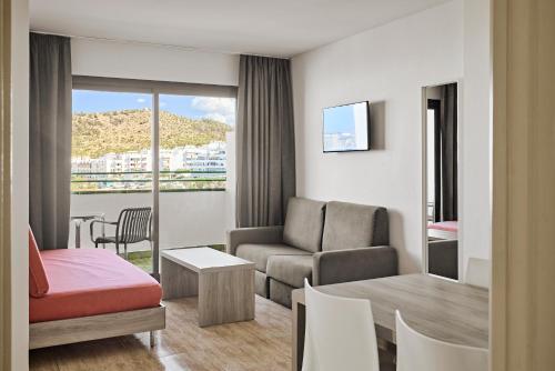 a living room with a couch and a table at Apartamentos Mar i Vent in San Antonio