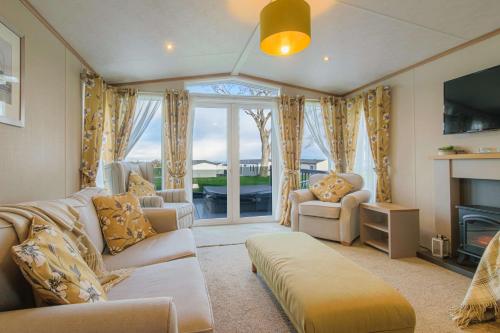 a living room with a couch and a fireplace at Hot Tub Lodge 31 Cameron, St Andrews in St. Andrews
