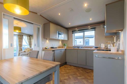 a kitchen with white cabinets and a wooden counter top at Hot Tub Lodge 31 Cameron, St Andrews in St. Andrews