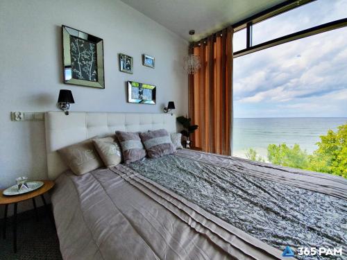 a bedroom with a large bed with a view of the ocean at 365PAM - Boulevard Z Widokiem Na Morze in Ustronie Morskie