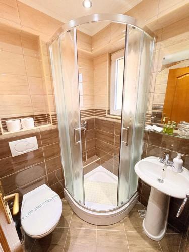 a bathroom with a shower and a toilet and a sink at Garni Hotel Bokeška Noć in Herceg-Novi