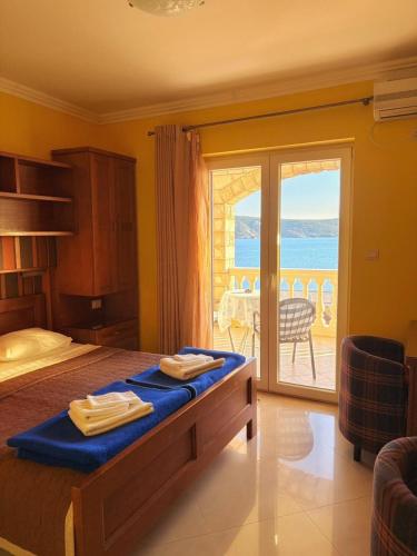 a bedroom with a bed with a view of the ocean at Garni Hotel Bokeška Noć in Herceg-Novi