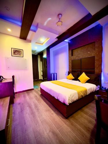 a bedroom with a large bed with purple lighting at Hotel Cosmos in Lucknow
