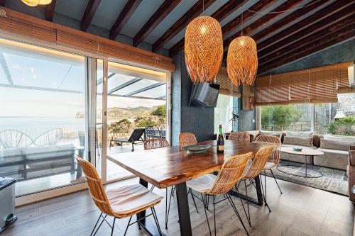 a dining room with a wooden table and chairs at Villa Ca La Dolors - Cala Deià, by PriorityVillas in Deia
