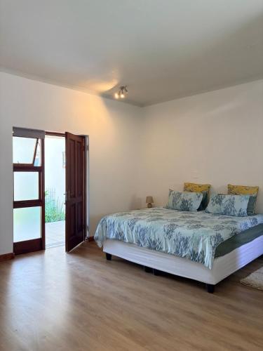 a bedroom with a bed and an open door at Le Grec Wine Tram Apartment #2 in Franschhoek