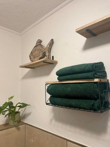 a bathroom with green towels on a wall at Gartenblick in Blankenheim