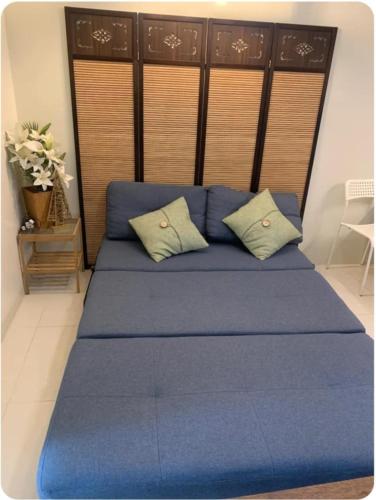 a blue bed with two pillows in a room at Sandstone Unit Brenthill Condo in Baguio