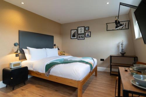 a bedroom with a large bed and a table at Lamington Apartments - London Hammersmith in London