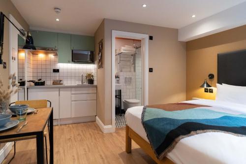 a hotel room with a bed and a kitchen at Lamington Apartments - London Hammersmith in London