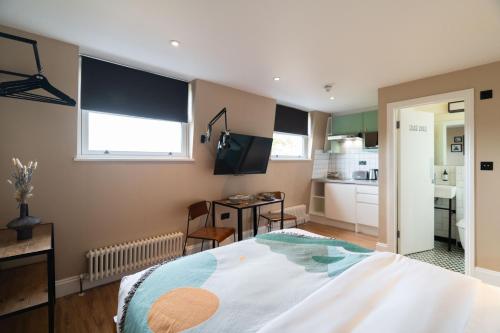 a bedroom with a large bed and a kitchen at Lamington Apartments - London Hammersmith in London