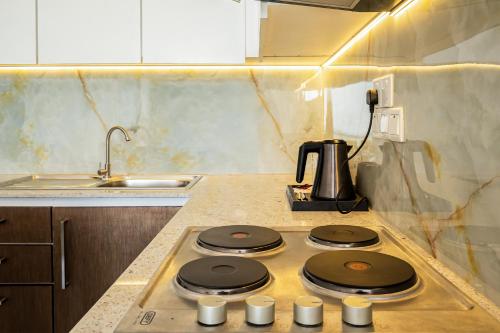 a kitchen with a stove with four burners on it at Corundum Breeze Negombo in Negombo