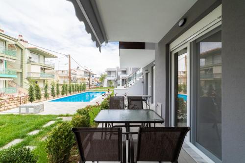 a table and chairs on a balcony with a view of a pool at Perla Stay Complex by Horizon Homes in Ofrínion