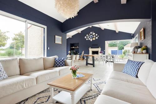 a living room with a white couch and a table at Tour Maréchal - Villa d'Exception in LʼHerbergement