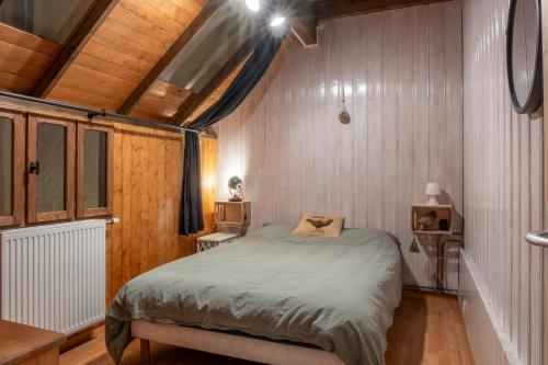 a bedroom with a bed in a room with wooden walls at Gite les fans in Prénovel