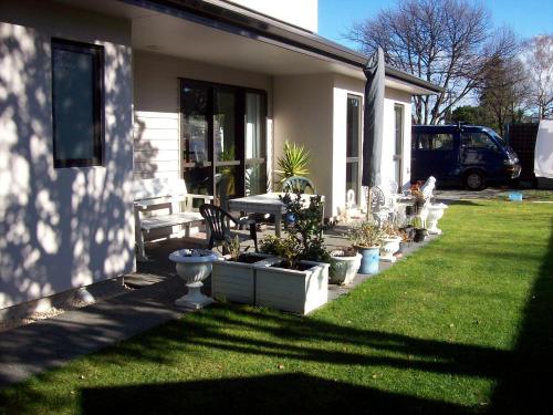 a house with a yard with potted plants at Stream View in Christchurch