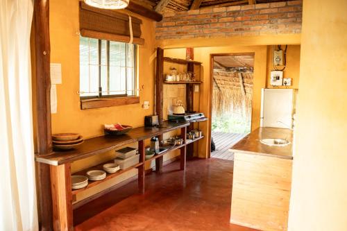 a kitchen with a counter with a sink and a refrigerator at Tofinho Beach House in Praia do Tofo
