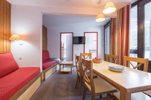 a living room with a dining room table and a couch at Résidence Pierre & Vacances Les Combes in Les Menuires
