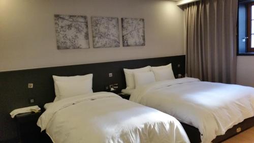 two beds sitting next to each other in a bedroom at Kobos Hotel in Seoul