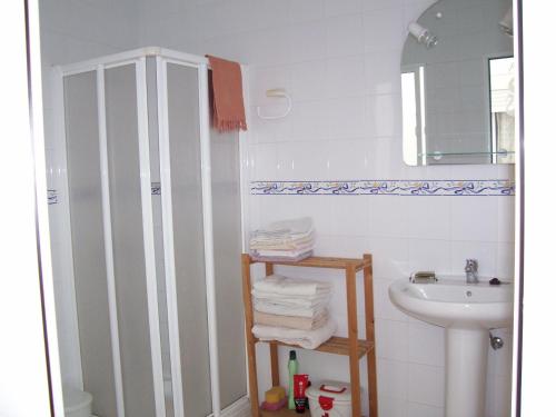 a white bathroom with a sink and a shower at Casa Amigo in Castaño de Robledo