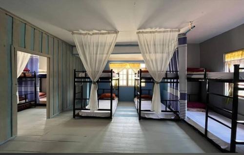 Una habitación con tres literas y un pasillo. en Queen house, en Vang Vieng