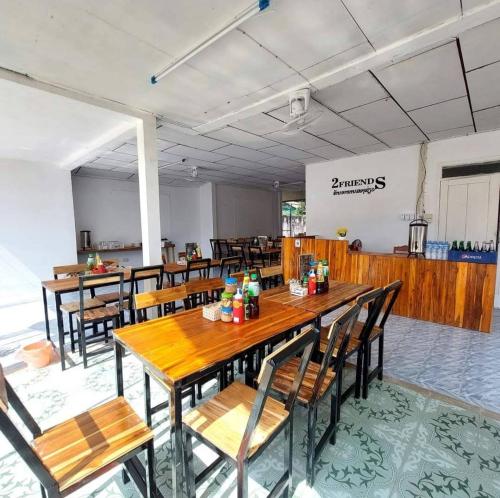 Un comedor con mesas y sillas de madera. en Queen house, en Vang Vieng