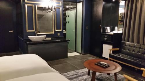 a bedroom with a bed and a bathroom with a sink at Kobos Hotel in Seoul