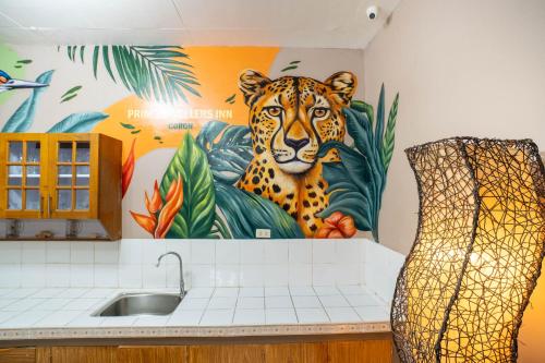 a mural of a leopard on the wall of a kitchen at Prim Travellers Inn in Coron