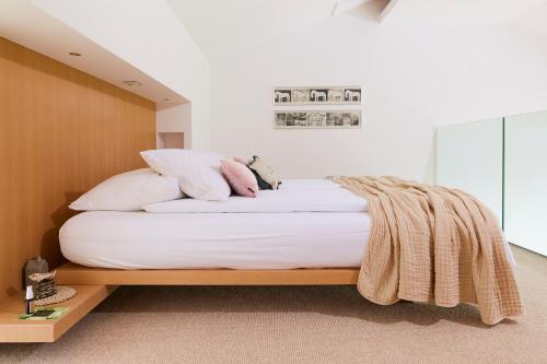 a bedroom with a bed with white sheets and pillows at Villa Alma Vista in Dobrovo