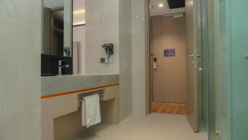a bathroom with a sink and a mirror at Nusatu by ARTOTEL - Semarang in Semarang