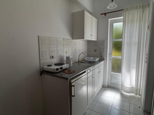 a kitchen with white cabinets and a counter top at Pelagos Studios in Amoudi