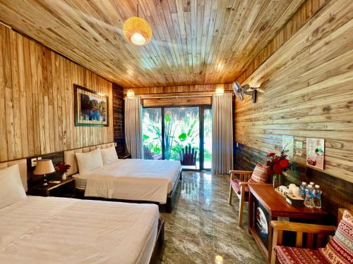 two beds in a room with wooden walls at Peaceful Garden Tam Cốc in Ninh Binh