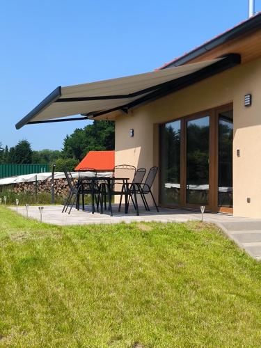 a patio with a table and chairs in front of a house at Chata U Bezedné in Velký Osek